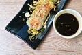 large rice noodles wrapped bean sprout and slice tofu topping fried egg on plate dipping spicy black soy sauce Royalty Free Stock Photo