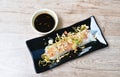 Large rice noodles wrapped bean sprout and slice tofu topping fried egg on plate dipping spicy black soy sauce Royalty Free Stock Photo