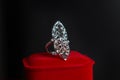 A large ring with small gems on a red box on a dark background. Women`s jewelry Royalty Free Stock Photo