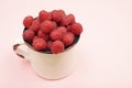 Large ripe raspberries in a mug