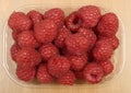 Large ripe raspberries in a plastic container