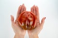 A large ripe red tomato lies in the female palms