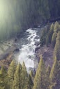 Large river waterfall cutting through trees in the woods