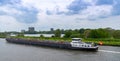 Large riverboat barge tranporting goods along the wide canals of Amsterdam Royalty Free Stock Photo