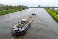 Large riverboat barge tranporting goods along the wide canals of Amsterdam Royalty Free Stock Photo