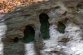 Large rock formation featuring several naturally carved holes set in an outdoor environment