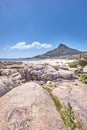 Large rocks at a beach near a mountain with a blue sky background on a hot summer day. The landscape of a rocky sea or Royalty Free Stock Photo