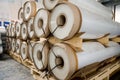 Large rolls of transparent polyethylene lie on a pallet.