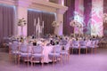 many large tables sitting in front of purple wallpapered curtains