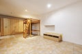 Large room with stoneware floors, wooden structure for a raised double bed and cabinets covering one wall Royalty Free Stock Photo