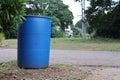 Large round blue plastic trash can placed in village street, garbage disposal concept, garbage sorting.