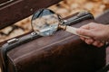 Large round magnifier on long handle in detective hand