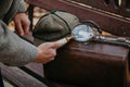 Large round magnifier on long handle in detective hand