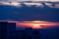 large round orange sunrise with cloudy sky over city Royalty Free Stock Photo