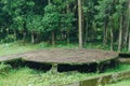 Large round stone platform is surrounded by trees and grass, forest nature background Royalty Free Stock Photo