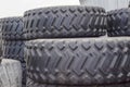 Large rubber tires for trucks lying on the street. Black tires close up with a large tread lie on top Royalty Free Stock Photo