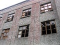 A large ruined brick building with broken Windows forgotten junk