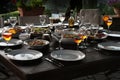 Large rustic table prepared with mediterranean salads and antipasti for a garden dinner at night