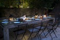 Large rustic table prepared for a outside dinner at night