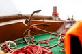 Large rusty anchor on an old fishing boat tied with a red rope to the boat, selective focus Royalty Free Stock Photo