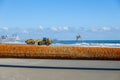 Large rusty pipe above wet sand on a beach near the ocean with yellow earth mover tractor in the background