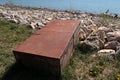 Large rusty rectangular steel chest placed on rocky river bank as storage for fishermen tools. Royalty Free Stock Photo