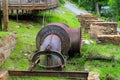 A large rusty steam pipe sitting on a hillside filled with lush green grass and plants surrounded by lush green trees Royalty Free Stock Photo