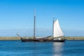 A large sailing ship with white sails is on the water