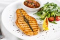 The large salmon steak red fish on the grill with lemon, sauce and