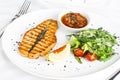 The large salmon steak red fish on the grill with lemon, sauce and vegetables