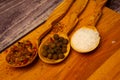 Large salt and various ground spices in wooden spoons on a wooden Board. Close up Royalty Free Stock Photo