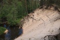 Large sand dune and a narrow small river in a pine forest Royalty Free Stock Photo