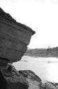 Large Sand stone canyon cliff shoreline of Mekong river and local fisherman sit under evening light