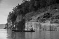 Large Sand stone canyon cliff shoreline of Mekong river and local Thai fisherman