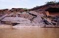 Large Sand stone canyon cliff shoreline of Mekong river and local Thai fisherman