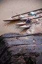 Large Sand stone canyon cliff shoreline of Mekong river and local Thai fisherman working in wooden boat