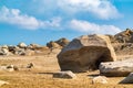 Large sandy beach with stone boulders and blue sky