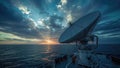 Large satellite dish on boat receiving data at sunset over ocean Royalty Free Stock Photo
