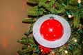 Large Saturn Christmas Ornament on artificial tree with red and white lights and strange otherworldly reflections on walls Royalty Free Stock Photo