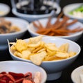 Large savoury snack food selection in porcelain bowls