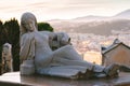 Large sculpture of a woman at old cemetery. Close Up of stone figure and cross monument at cemetery. Old stone Graveyard statue on