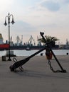 A large sea anchor adorns the walking part of the port, in the background are the water area of the port, cargo ships and cra Royalty Free Stock Photo