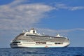 Large seagoing passenger ship in the sea and next to a small boat, blue sea and blue sky Royalty Free Stock Photo