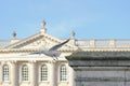 Large seagull seen jumping off a stone column near a majestic building.