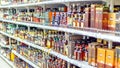 A large selection of alcoholic beverages on the shelves of the supermarket. Text on russian: action, rum, tequila,