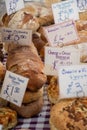 Large selection of Artisan home cooked bread on table with price labels for sale