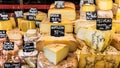 Different cheeses on the counter of a small store at the market.