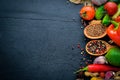 A large selection of raw vegetables, fruits and spices on a black wooden surface. Royalty Free Stock Photo