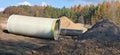 Large sewer pipes and pile of sand in a autumn forest const Royalty Free Stock Photo