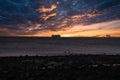 Large shipping vessel in distance with beautiful sunset sky and beach in foreground Royalty Free Stock Photo